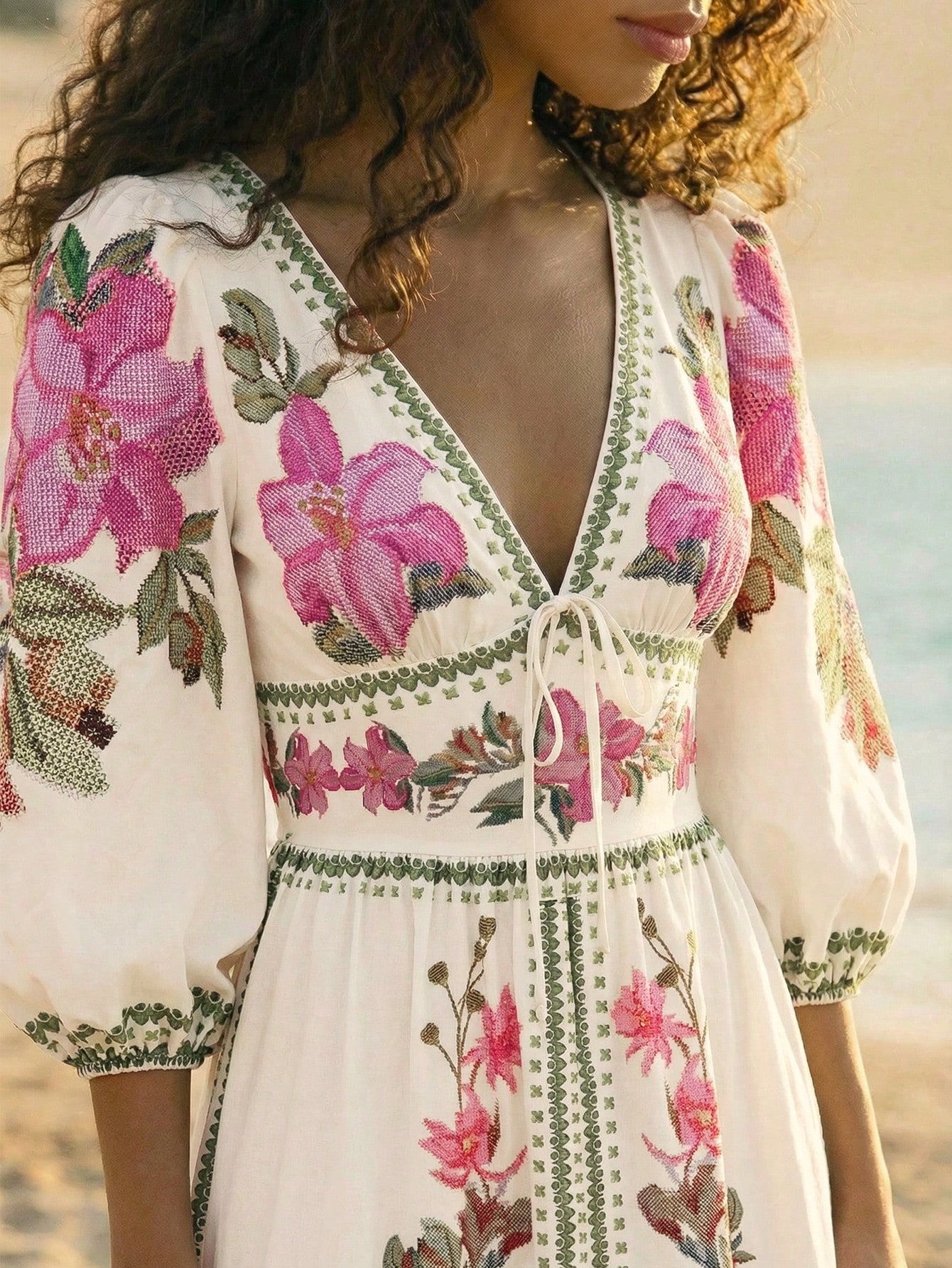 Detalhe do floral rosa e dos acabamentos verdes do vestido